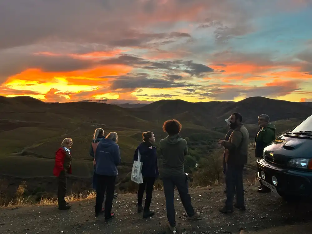 Tour group watching the sunset by the Ambieduca van